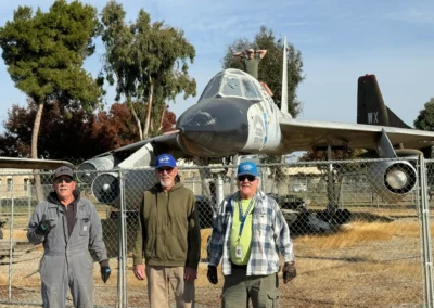 Three men standing in front of jet.