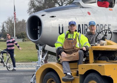 People with aircraft and yellow vehicle.